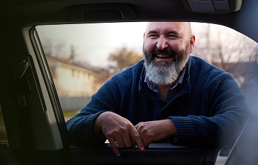 Robert looking into a car and laughing
