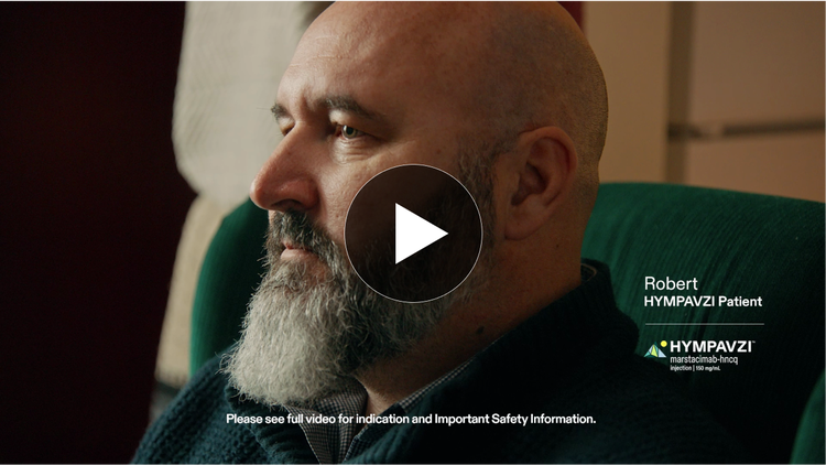Video thumbnail of Robert, a real HYMPAVZI patient, sitting on a couch with a thoughtful expression.