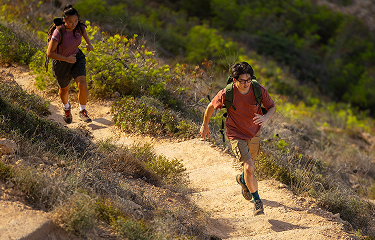 Actor portrayal of two adult males hiking