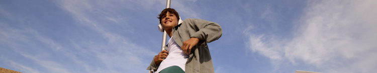 Actor portrayal of an adult male smiling wearing white headphones