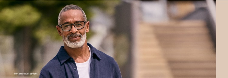 Actor portrayal of a man wearing glasses looking into the camera